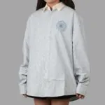 Mardi Mercredi Flowermardi Oxford Shirt Sky Blue dengan bordir bunga Mardi Mercredi di dada, berbahan cotton berstruktur, berpotongan relaxed fit dan cocok untuk gaya kasual formal